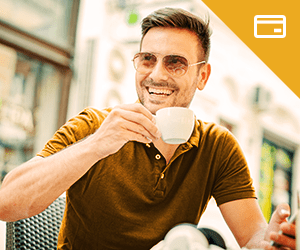 A young man wearing sunglasses sipping coffee