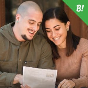 A young couple happily looking at financial documents.