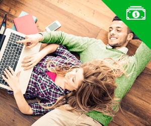 A young couple laying on the floor using a laptop